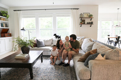 A family, the Brinns, relaxes together on a couch in their cozy living room.