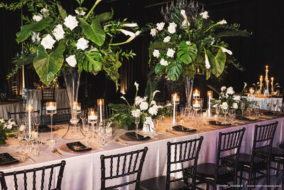 Floral-decorated table with champagne, mirror backdrop.