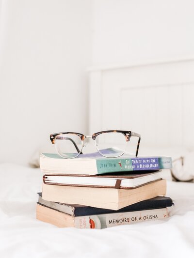 stack of books with glasses on top