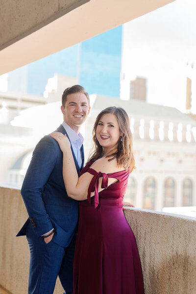 Bride in a white strapless wedding gown and groom in a white and black tux walking hand in hand smiling at each other down a path in front of Hotel Crescent Court at downtown Dallas wedding with Stefani Ciotti Photography