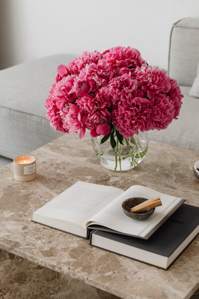 Bouquet of pink peonies in a vase on a marble table