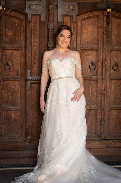 Beautiful bride sits on a setee in her wedding gown