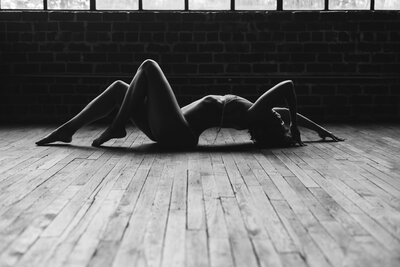woman in a boudoir pose, arched on the floor