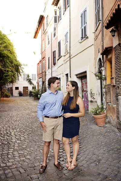 A couple lovingly looking at each other on a cobblestoned street. Taken by Rome Photographer, Tricia Anne Photography