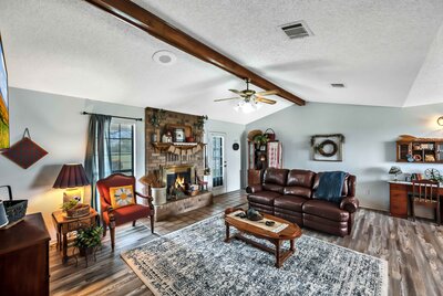 Open concept living area with brick fireplace in this 3-bedroom, 2.5 bathroom rural vacation rental house just minutes outside of downtown Waco, TX.