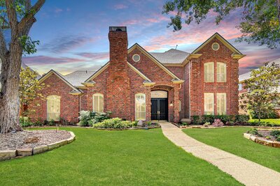 Exterior view of 4820 Holly Tree in Dallas, listed by Haven Realty Group. Traditional brick home with double door entry and manicured front yard.