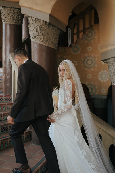 bride and groom showing off wedding bands