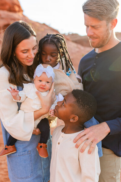 dad hugging his two kids who are laughing during family photos