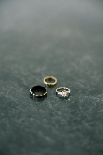 Three wedding rings on tile floor.