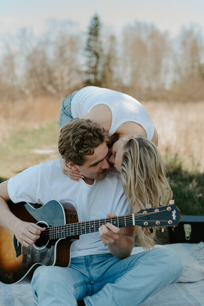 Engagement couple kissing in the woods.