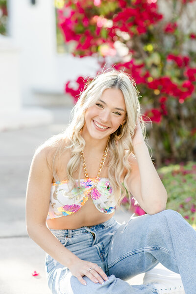 girl smiling in a floral top and jeans