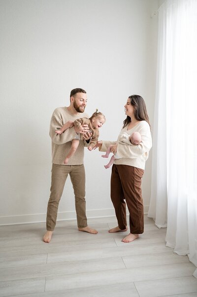 family of four posing in a Dallas newborn studio