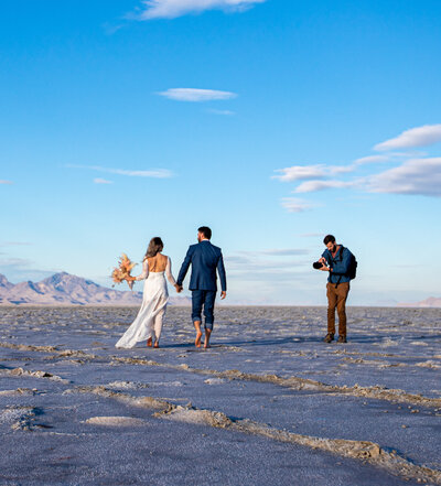 James taking photos of a couple walking on the bonneville salt flats in Utah