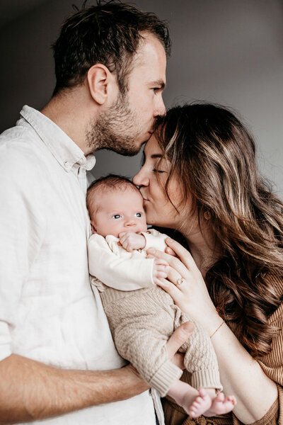 papa en mama kussen elkaar en de baby