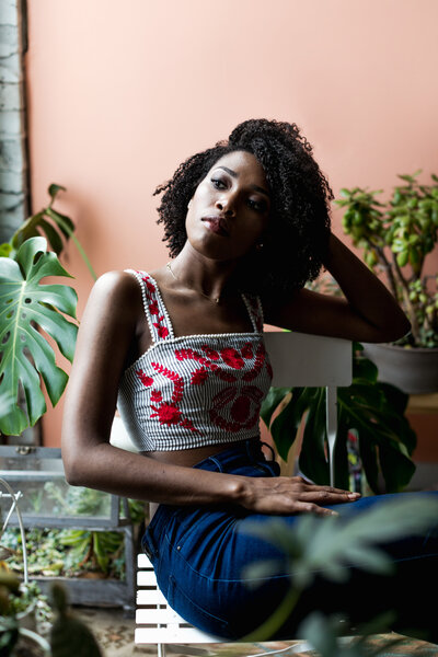 black woman with plants and window light