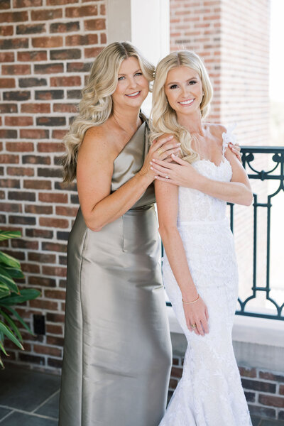 Black and white photo of bride's mother zipping up her dress