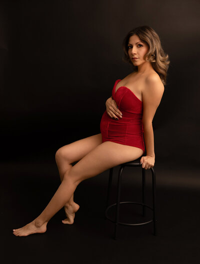 Pregnant mother in a black long skirt and matching top with belly showing. 