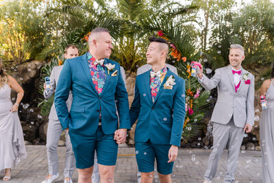 two grooms walking holding hands at their union brick wedding