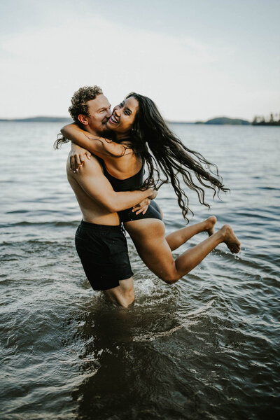 man and woman laughing and standing in water