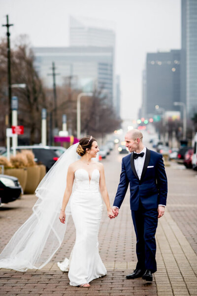 bride and groom walking holding hands in downtown cleveland at winter cleveland wedding