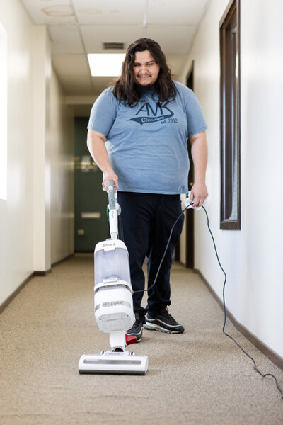 Professional cleaner vacuuming hallway 