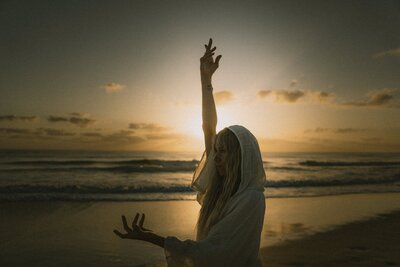 HarJiwan posing with arms up at sunset