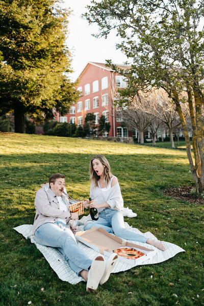 couple is popping champagne and eating pizza on the grass in the presidio of san francisco