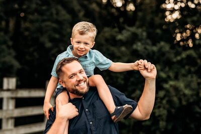 Fall family photography session of little boy sitting on dad's shoulders in Bloomington/Normal, Illinois