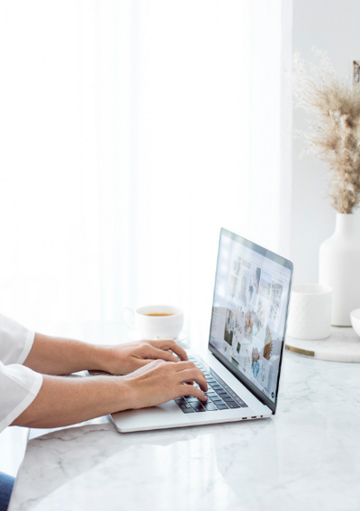 A person working meticulously on a laptop, symbolising the professional website design services offered by The Purple Flamingo.