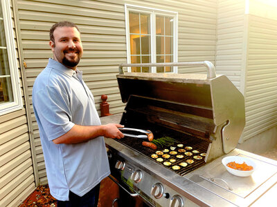 Man grilling outside on bbq having a barbecue  hosting  cooking on grill burgers hotdogs vegetables entertaining, i don't want my baby, unplanned pregnancy, adoption agencies  local near me, new york, long island, northeast
