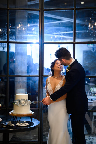 bride looks at groom while cutting cake in Elora Mill Hotel & Spa