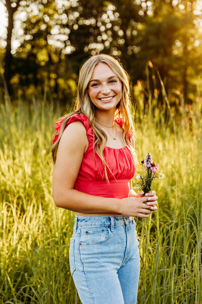 gorgeous high school senior girl holding a bouquet of flowers during her senior photo session