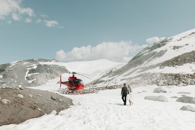 Bride and Groom walking to helicopter on top of snowy Whistler Mountain