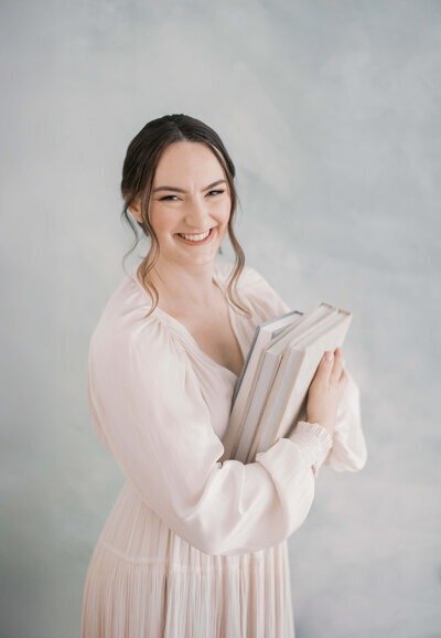Laurel Smith, san francisco photographer, holding photo albums and smiling