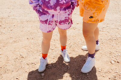 Close up of two people's legs with purple and orange clothing.