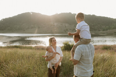 Stephen and Kaity from Rainstorm Photo & Video spending time with their two children in the dunes at sunset, photographed in a natural, heartfelt storytelling style.