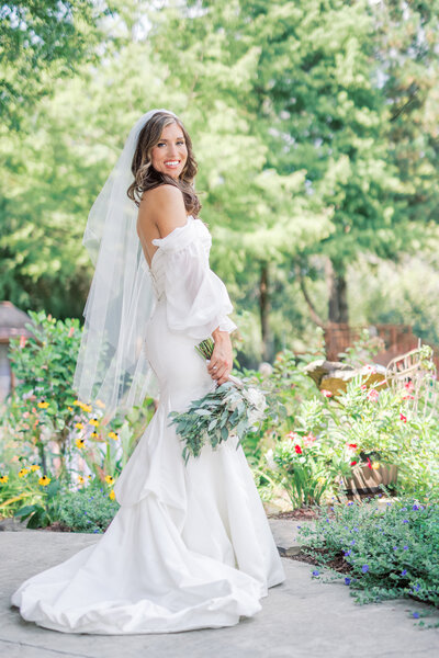 A bride wearing her veil and holding a bouquet of flowers