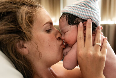 Pasgeboren baby na een badbevalling, vastgelegd door een geboortefotograaf.