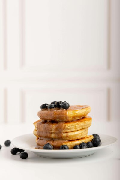 Megan Boswell eating disorder dietitian with stack of waffles demonstrating food freedom approach to nutrition recovery Australia