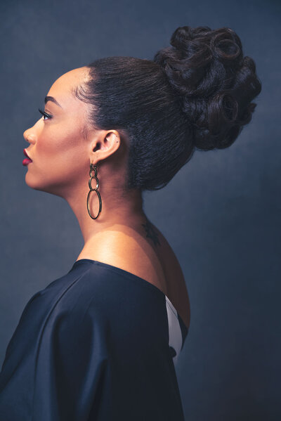 A side profile fine art portrait with her hair up  by Poplight Photography