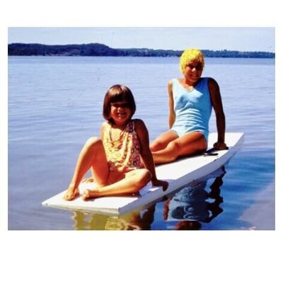 young girls playing on paddle board on lake