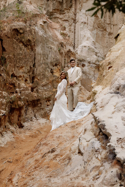 Red rock canyon frames a tender moment between a couple, captured by a travel elopement photographer. 