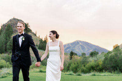newlyweds walk in front of mountain