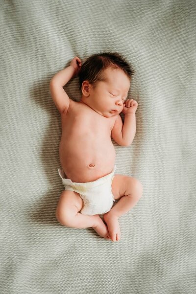 newborn photo with mom and dad looking happily down at baby daughter