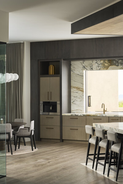 JSF Design kitchen with marble backsplash and stone-inlaid wood floors around a central island