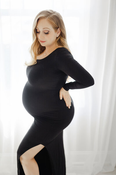 Elegant Tampa maternity portrait of expectant mother in black gown in soft natural light