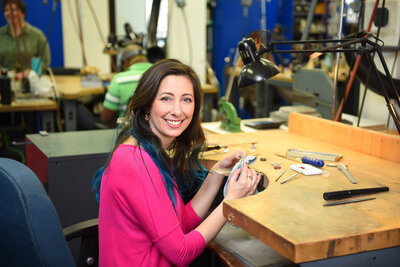 jeweller at her workstation in pink top