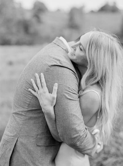 Black and white candid portrait of a couple embracing on the beach, highlighting storytelling in editorial and destination wedding photography.
