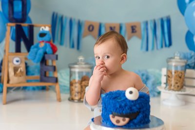 one year old boy celebrating his birthday with a cake smash studio session
