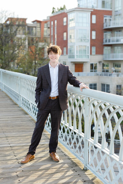 senior boy posing for portraits on Walnut Street Bridge